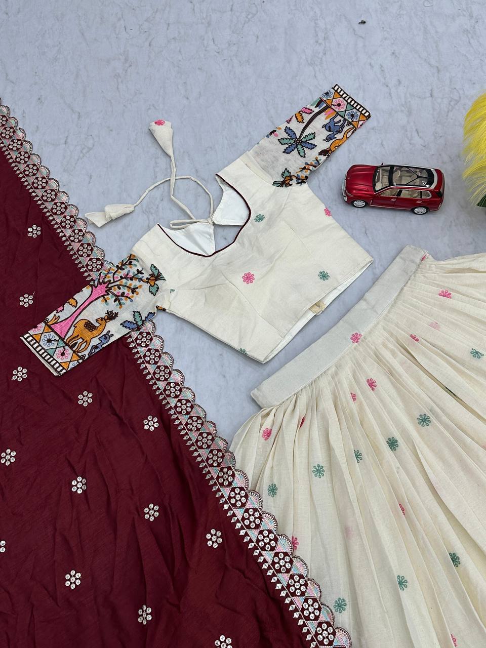 Delightful Embroidery Work Cream Color Lehenga With Maroon Dupatta